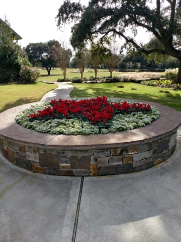 Stone planter with red and white seasonal colors at a golf course