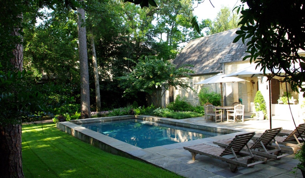 A custom swimming pool and green landscape designed, constructed and maintained by a landscape architecture firm.