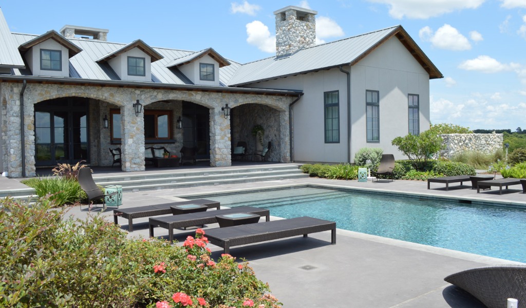 Outdoor landscaping design featuring a swimming pool, loungers and covered patio.